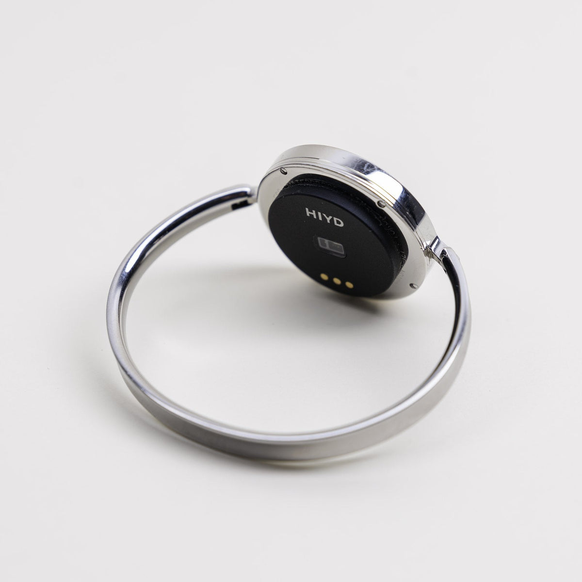 A silver bangle watch turned over, with the HIYD sensor fitted to its caseback