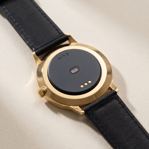 The Hiyd tracker seated on the caseback of a slim gold dress watch
